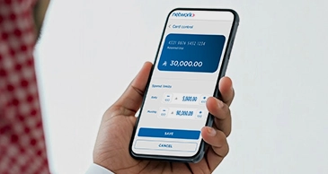 Close-up of a hand holding a smartphone displaying the Network app’s card control screen showing a balance of 30,000 SAR.