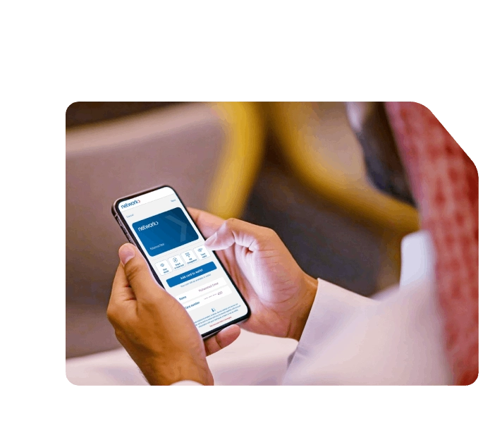 Man in traditional attire using his smartphone to access the Network app, viewing digital card details and wallet options.