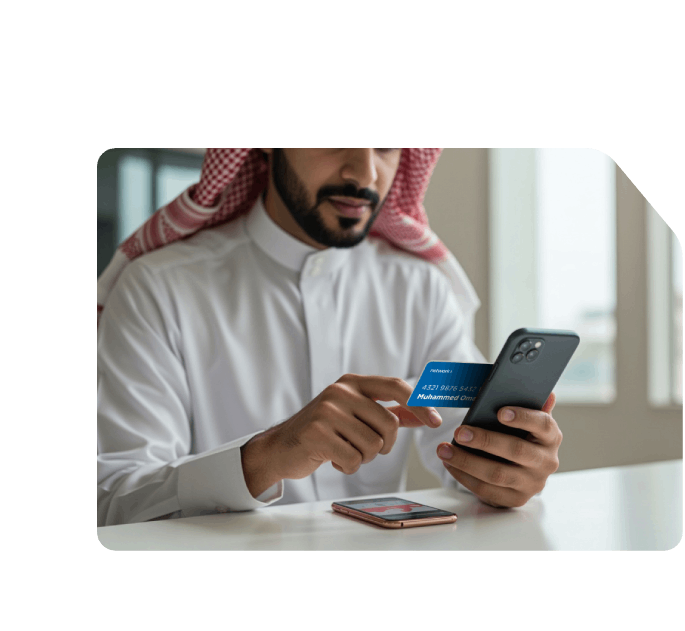 Saudi man holding a Network payment card and smartphone, appearing to make a secure online payment or mobile transaction.