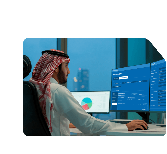 Saudi man analyzing data on dual monitors displaying Network’s AML dashboard, focused on compliance and transaction monitoring.