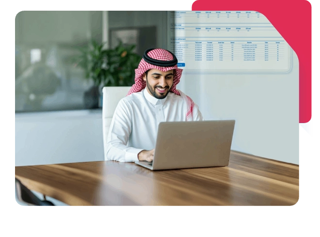 Smiling Saudi man in thobe working on laptop at desk in modern office.