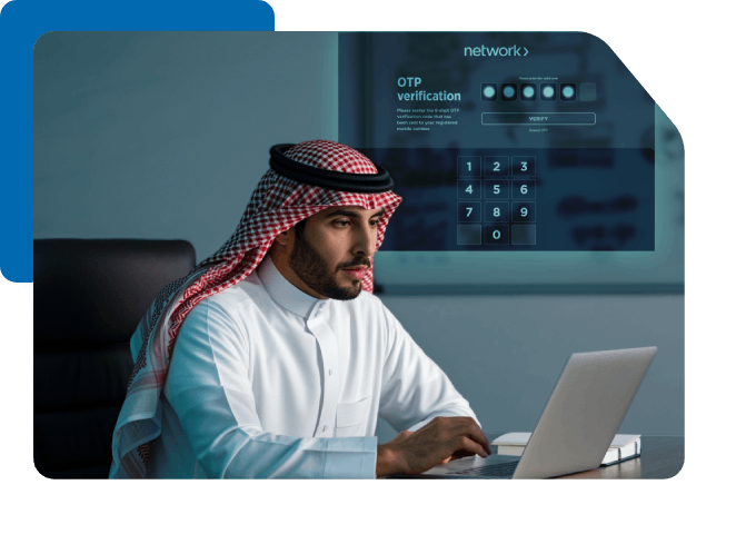 Saudi man using a laptop with a holographic Network OTP verification screen, symbolizing secure digital authentication.