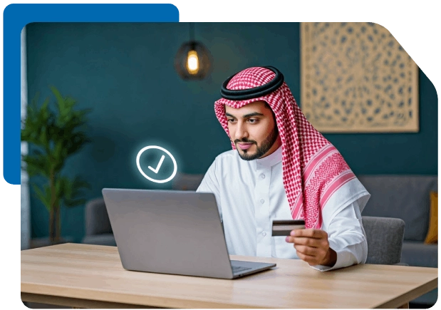 Saudi man holding a credit card and using a laptop, symbolizing secure online payment or digital banking.