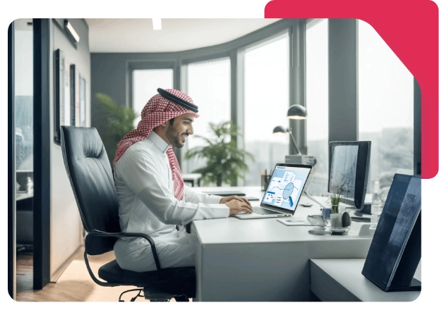 Smiling Saudi man working on a laptop in a modern office, analyzing business data on the screen.
