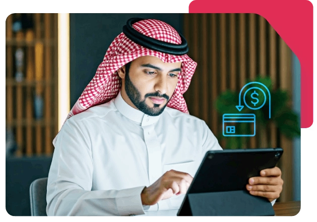 Man in Arab attire uses tablet with glowing dollar and card icons for fintech.