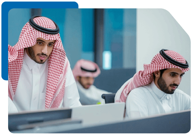 Saudi men in thobes collaborating in a professional workspace.